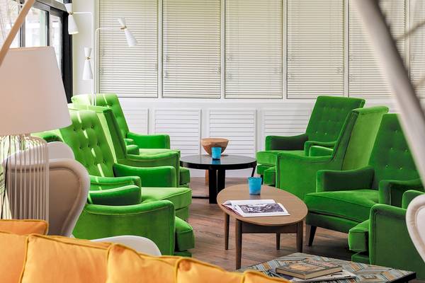 Loungebereich im H10 Lanzarote Princess Hotel mit grünen Sesseln und Couch.