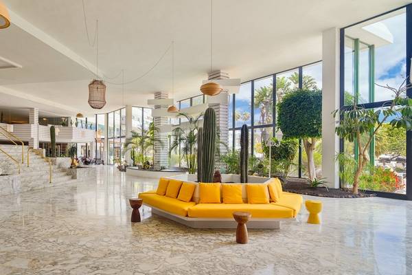 Lobby des H10 Lanzarote Princess Hotels mit gelben Sofas, hängenden Laternen und Pflanzen