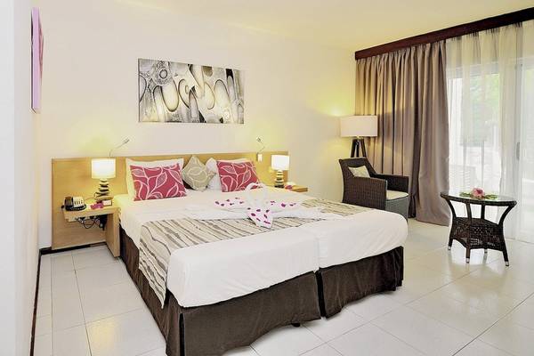 Hotelzimmer im Casuarina Resort & Spa mit zwei Betten, Dekor und Möbeln.