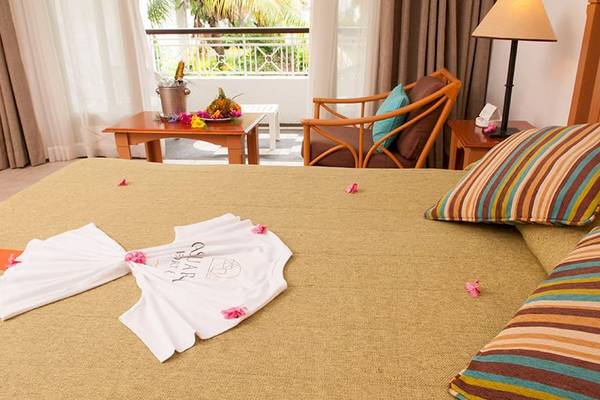 Hotelzimmer im Casuarina Resort & Spa mit Bett, Tisch, Stuhl und Balkon.