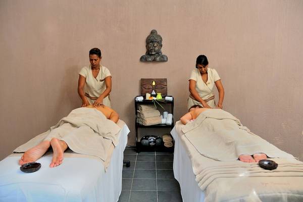 Zwei Frauen erhalten Massagen im Casuarina Resort & Spa, beide liegen auf Massagetischen mit Handtüchern.