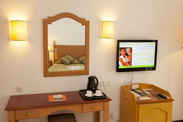 Zimmer im Casuarina Resort & Spa mit Schreibtisch, Spiegel und Fernseher.