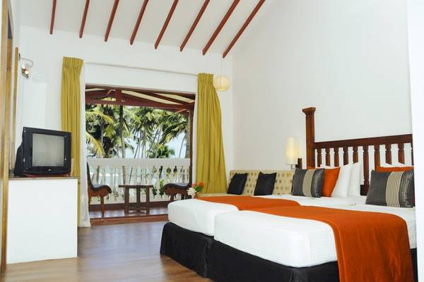 Doppelbett-Zimmer im Siddhalepa Ayurveda Health Resort mit Balkon und Meerblick.