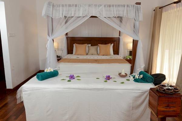 Schlafzimmer im Siddhalepa Ayurveda Gesundheitsresort mit luxuriösem Bett und Wellness-Elementen.