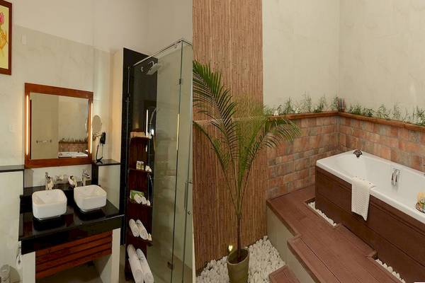 Ein Badezimmer im Siddhalepa Ayurveda Gesundheitsresort mit Badewanne, Dusche und Waschbecken.