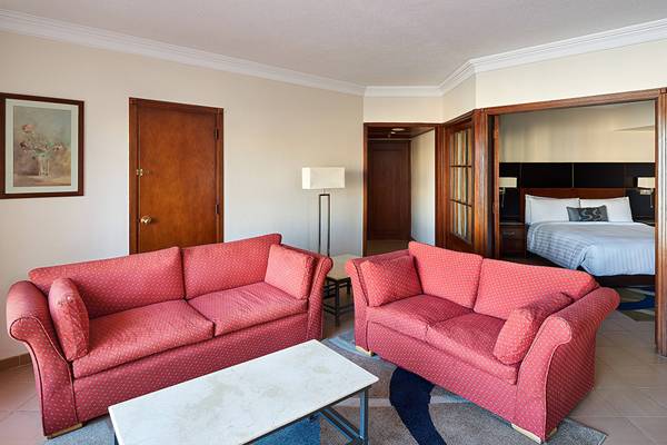 Wohnzimmer des Hurghada Marriott Beach Resorts mit zwei roten Sofas, einem Tisch und einem Bild an der Wand.