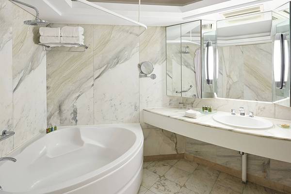 Badezimmer im Hurghada Marriott Beach Resort mit Badewanne, Spiegel und Marmorwänden.