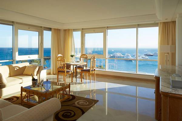Wohnzimmer des Hurghada Marriott Beach Resort mit Blick auf das Meer und mehrere Schiffe im Hafen.