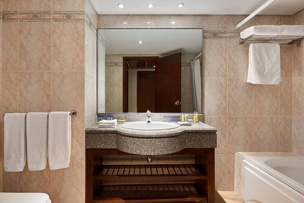 Badezimmer im Hurghada Marriott Beach Resort mit Waschbecken, Spiegel und Badewanne.