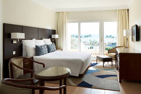 Ein Hotelzimmer im Hurghada Marriott Beach Resort mit Blick auf das Meer und Palmen.