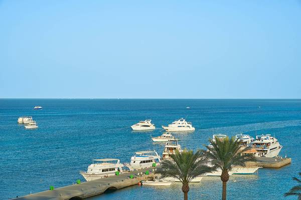Hafen des Hurghada Marriott Beach Resorts mit mehreren weißen Booten, darunter ein großes Boot mit der Aufschrift 'Monte Carlo'.