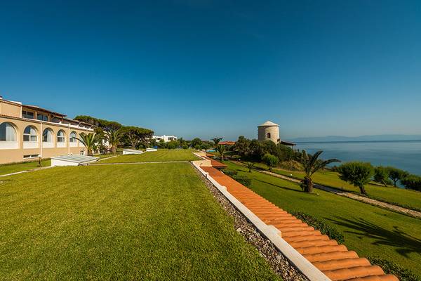 Außenansicht des Pavlina Beach Hotels mit Rasen, Gebäuden und Meer im Hintergrund