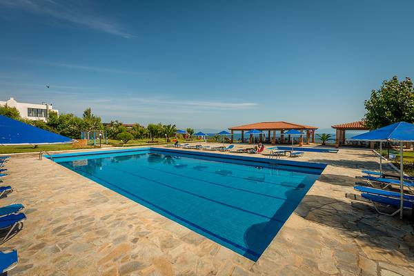 Außenpoolbereich des Pavlina Beach Hotels mit blauen Sonnenschirmen und Liegestühlen