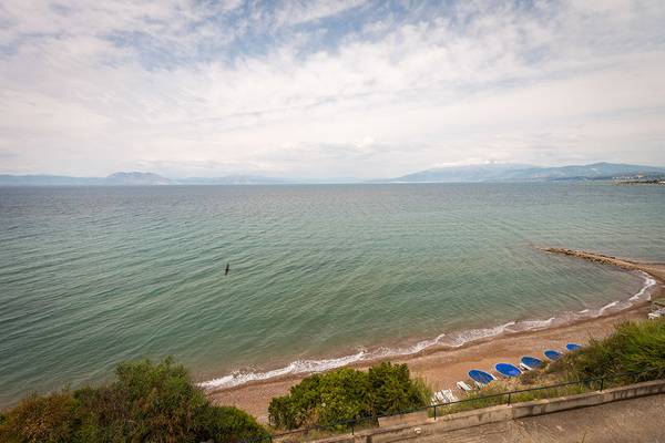 Aussicht auf den Pavlina Strand mit ruhigem Meer und Bergen im Hintergrund.