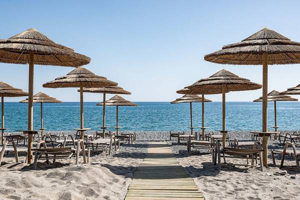 Strand des Euphoria Resorts mit vielen Sonnenschirmen und Tischen am Meer