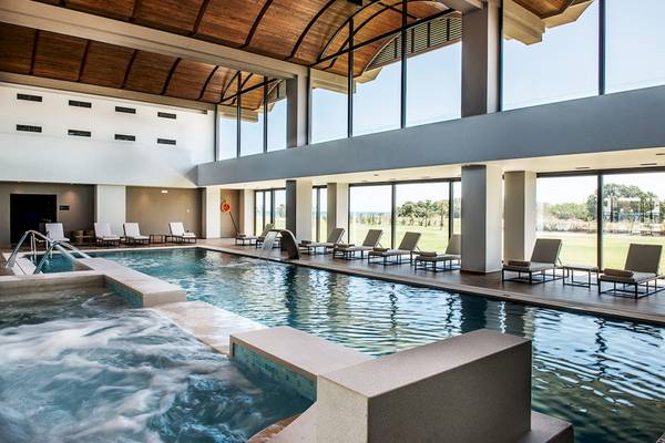 Innenpool des Euphoria Resorts mit Wasserfall und Liegestühlen an einem sonnigen Tag