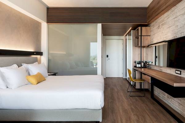 Innenansicht eines Hotelzimmers im Euphoria Resort mit Bett, Schreibtisch und Fernseher.