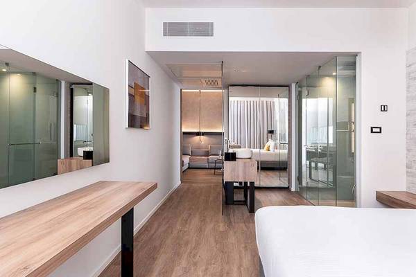 Innenansicht eines Zimmers im Euphoria Resort Hotel mit Bett, Tisch und Spiegel.