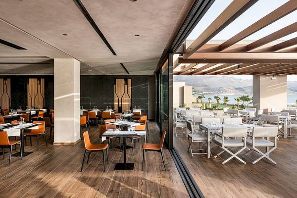 Innenansicht des Restaurants im Euphoria Resort mit Blick auf den Garten und das Meer.