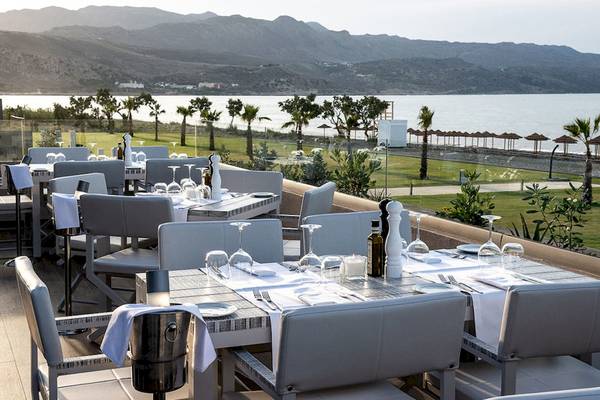 Aussenbereich des Euphoria Resorts mit Tisch und Stuhl und Meerblick.