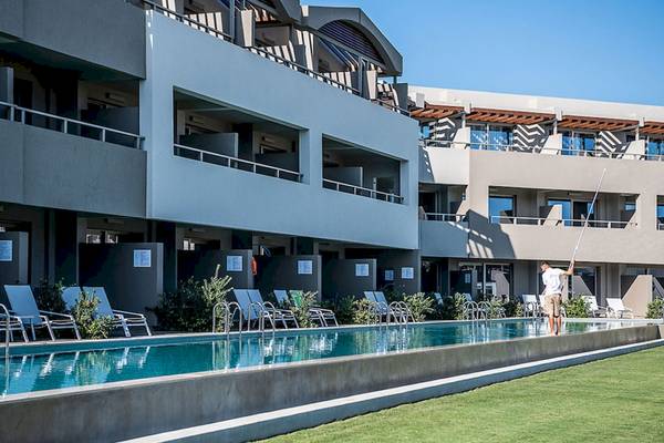 Mann, der den Pool im Euphoria Resort reinigt, umgeben von Gebäuden und Sonnenliegen.