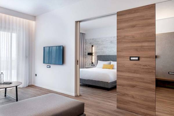 Innenansicht eines Zimmers im Euphoria Resort Hotel mit Fernseher, Bett und Tisch.