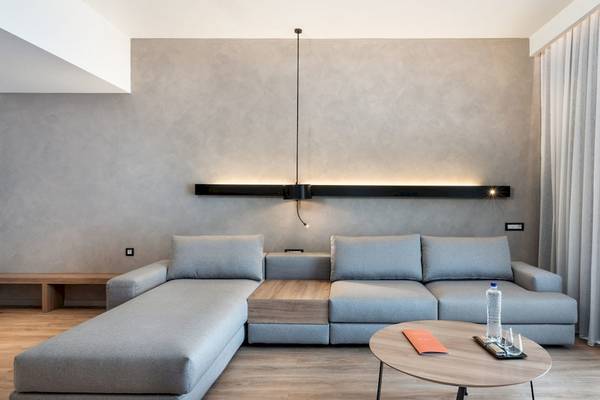 Wohnzimmer im Euphoria Resort mit grauer Couch, Holztisch und moderner Beleuchtung.