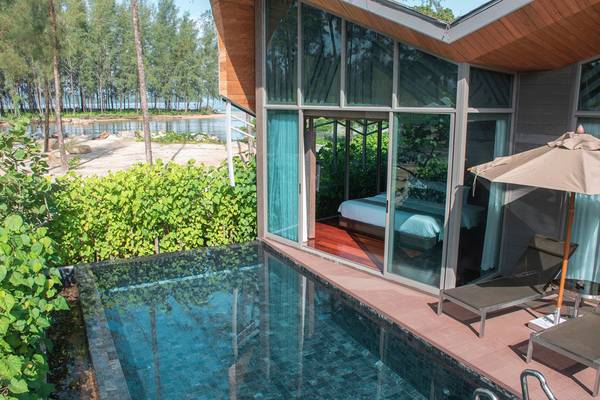 Eine Villa des Kalima Resort & Villas Khao Lak mit Swimmingpool und Sonnenliegen.