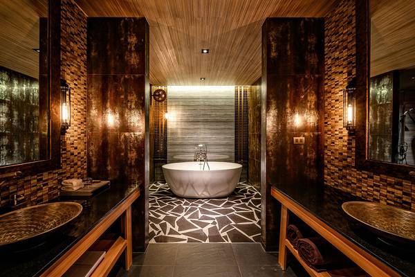 Ein Badezimmer im Kalima Resort & Villas Khao Lak mit einer großen Badewanne und modernen, rustikalen Elementen.