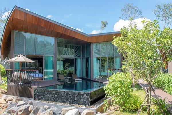 Außenansicht des Kalima Resort & Villas Khao Lak mit Swimmingpool und Loungebereich.
