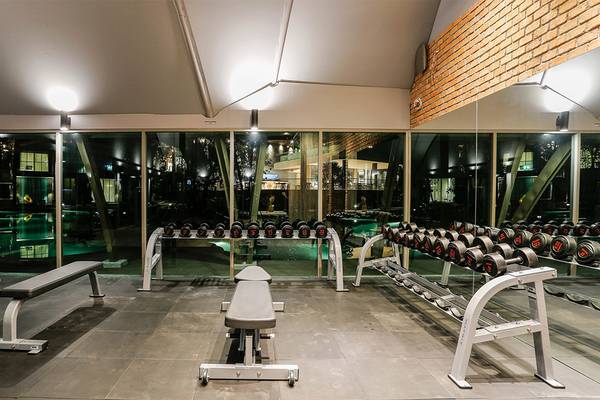 Fitnessstudio im Kalima Resort & Villas Khao Lak mit Geräten und großen Fenstern.