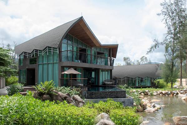 Außenansicht des Kalima Resort & Villas Khao Lak mit Swimmingpool und grüner Umgebung