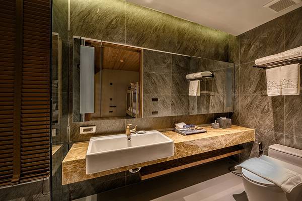 Das Badezimmer im Kalima Resort & Villas Khao Lak mit einer weißen Badewanne und einem Waschbecken.