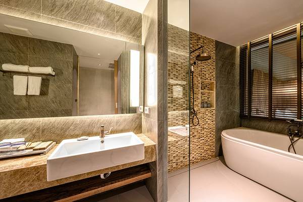 Ein Badezimmer im Kalima Resort & Villas Khao Lak mit einer Badewanne, einem Waschbecken und einem Spiegel.