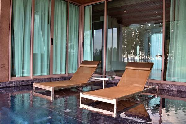 Zwei Loungeliegen am Pool des Kalima Resort & Villas Khao Lak