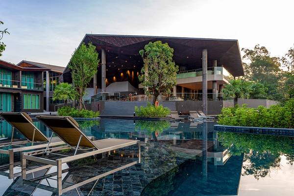 Außenbereich des Kalima Resort & Villas Khao Lak mit Pool und Loungeliegen