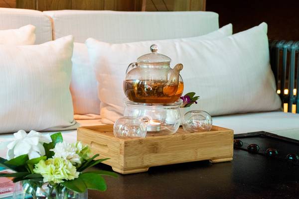Ein Teeservice auf einem Holztablett auf einem weißen Sofa im Kalima Resort & Villas Khao Lak