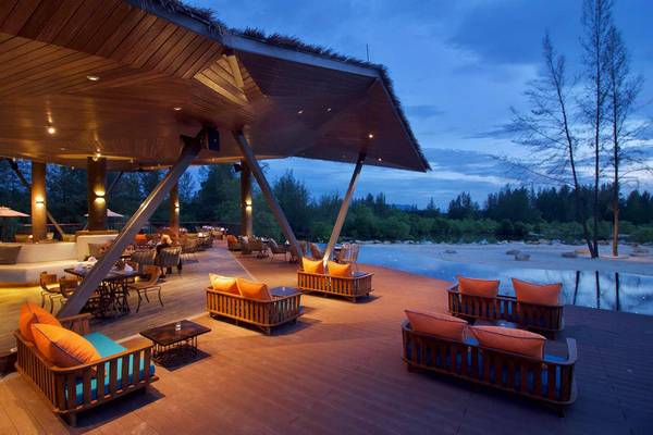 Außenbereich des Kalima Resort & Villas Khao Lak mit abendlicher Beleuchtung und Blick auf den See.