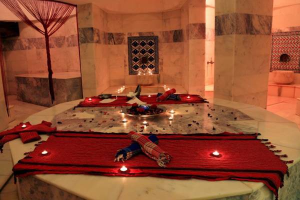 Innenansicht des LABRANDA Ephesus Princess Hammam mit rotem Teppich, Kerzen und Marmorwänden.