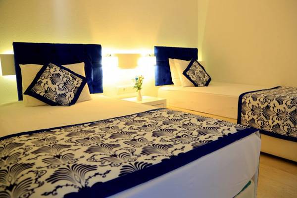 Doppelbett-Zimmer im LABRANDA Ephesus Princess Hotel mit blauen Kopfteilen und Blumenvase auf dem Nachttisch