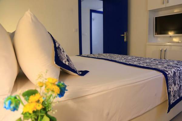 Innenansicht eines Hotelzimmers mit Bett, Kissen, Fernseher und Tür im LABRANDA Ephesus Princess Hotel.