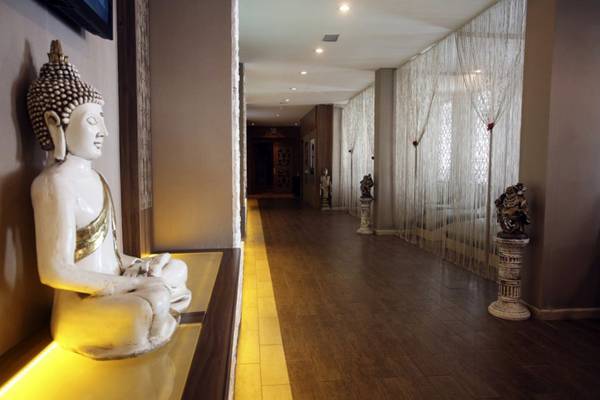 Blick auf einen Korridor des LABRANDA Ephesus Princess Hotels mit einer sitzenden Buddha-Statue.