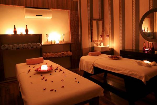 Massage-Behandlungsraum im LABRANDA Ephesus Princess Hotel mit zwei Behandlungstischen, Kerzen und Rosenblättern.