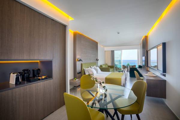 Innenansicht der Suite im Cavo Maris Beach Hotel mit Esstisch und Meerblick