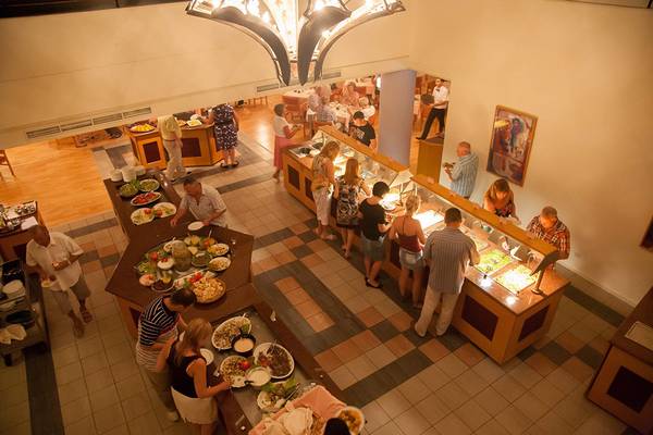Buffet im Hotel Queens Bay mit verschiedenen Speisen und Gästen, die essen.