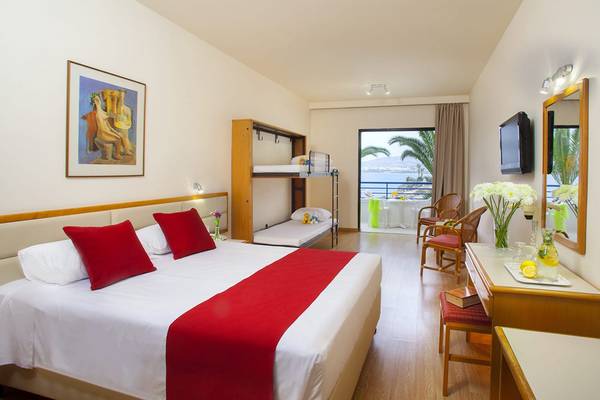 Ein Hotelzimmer im Queens Bay mit einem Bett, einem Schlafsofa und einem Ausblick auf den Balkon.
