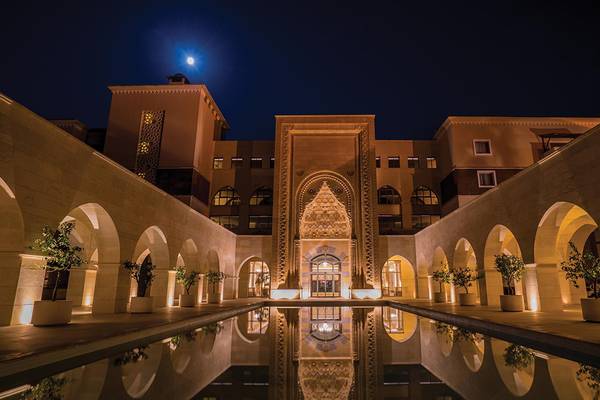 Außenansicht des Kempinski Hotel The Dome Belek bei Nacht mit Vollmond und Lichteffekten.