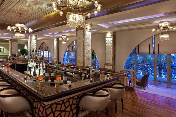 Barbereich des Kempinski Hotel The Dome Belek mit Marmortheke und Kronleuchtern.