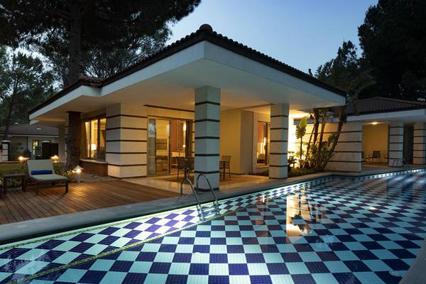 Außenansicht des Kempinski Hotel The Dome Belek mit Swimmingpool und Lounge-Bereich