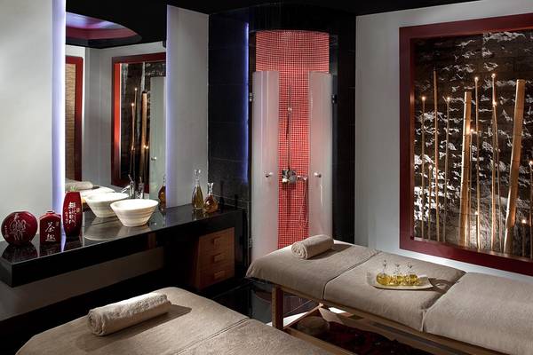 Spa-Behandlungsraum im Kempinski Hotel The Dome Belek mit zwei Massageliegen, Waschbecken und Wanddekoration.